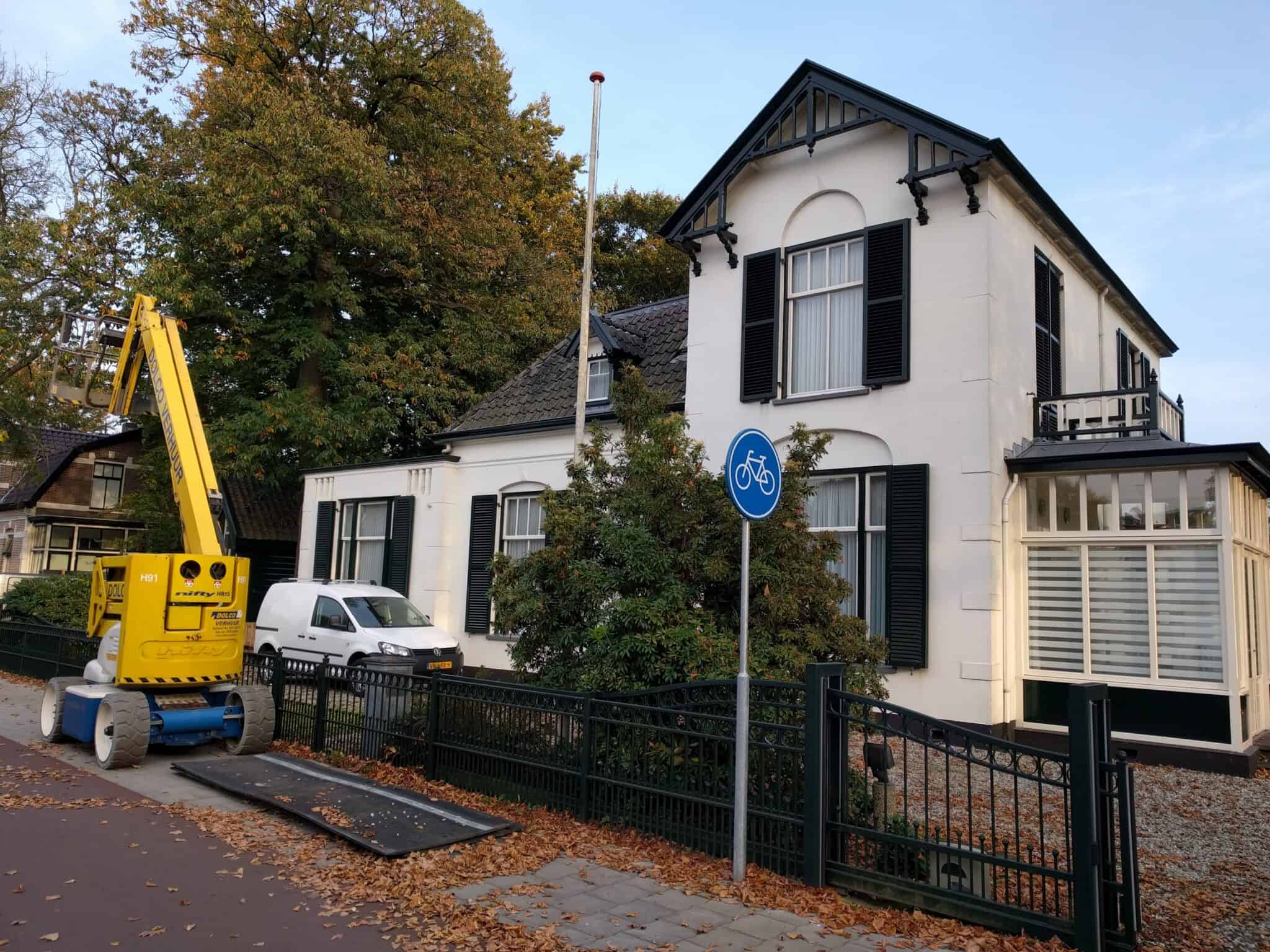 Woning waar dakgootroosters met een hoogwerker worden gemonteerd